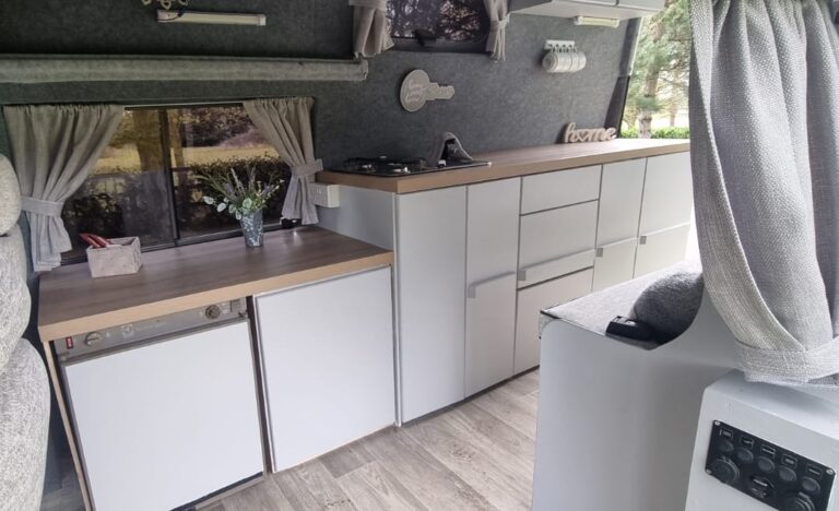 Betsy kitchen with fridge, sink and storage cupboards