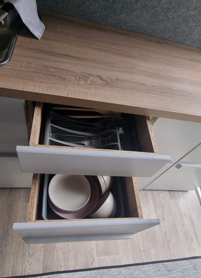 Betsy open drawers containing cutlery and crockery