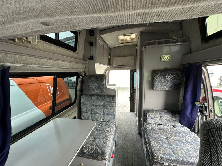 Shelby seating area with a table and overhead storage