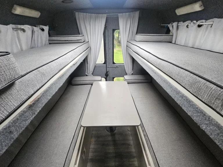 Grande rear sleeping area with upper bunks, bench seats and a table